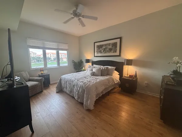 a bedroom with a bed couches chair and a large window