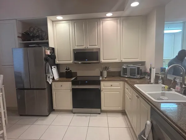 a kitchen with a refrigerator sink and cabinets
