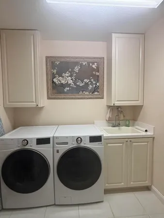 a utility room with sink dryer and washer