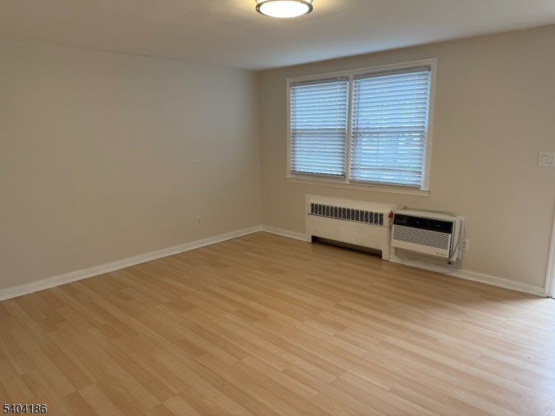 445 Morris Avenue, Unit 1A Springfield, NJ 07081 - Photo 4 of 9 an empty room with wooden floor and windows