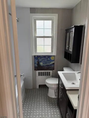 a bathroom with a sink toilet and window