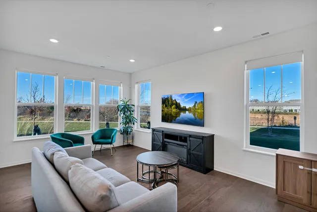 a living room with furniture tv and a large window