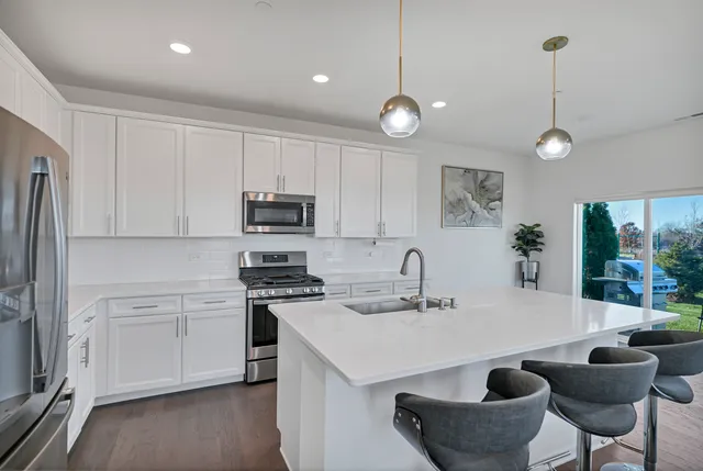 a kitchen with stainless steel appliances granite countertop a sink a microwave and cabinets