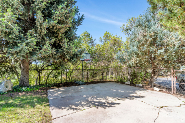 3813 North Foothill Drive Provo, UT 84604 - Photo 54 of 71 Outdoor activity area featuring a concrete pad, basketball hoop, and established perimeter fencing