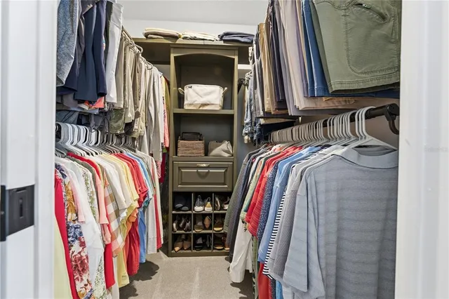 a view of walk in closet with clothes and shoes