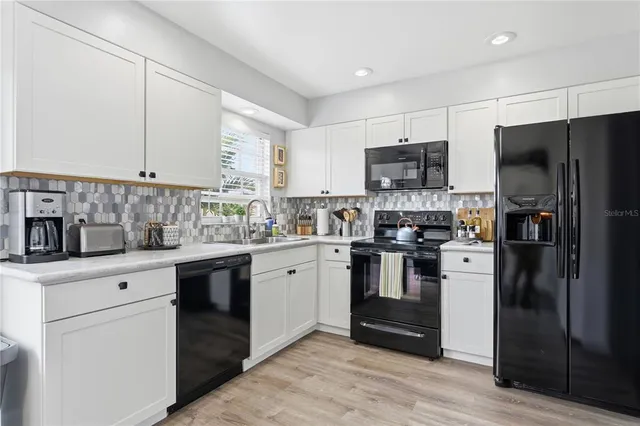 a kitchen with stainless steel appliances granite countertop a refrigerator and a stove top oven