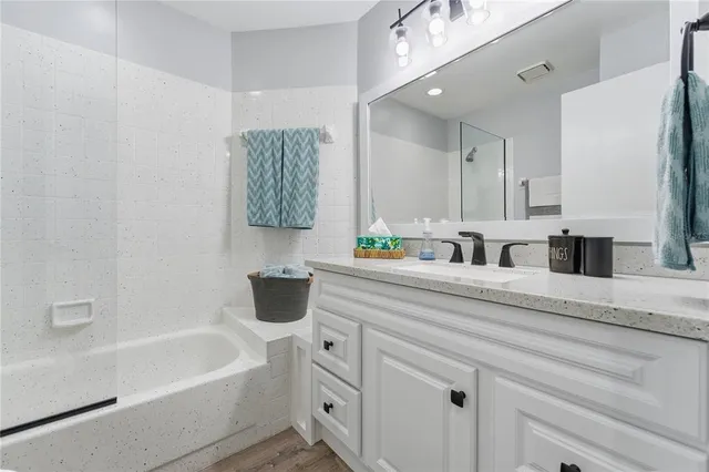 a bathroom with a sink a large mirror and a bathtub