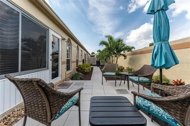 a view of a patio with table and chairs potted plants with wooden floor and fence