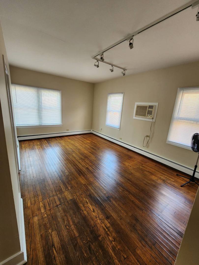 48 Crystal Street, Unit 2F Cary, IL 60013 - Photo 2 of 6 an empty room with wooden floor and windows
