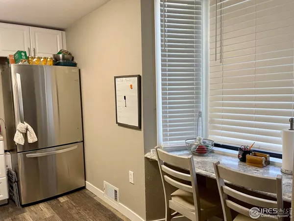 a kitchen with a refrigerator and table chairs