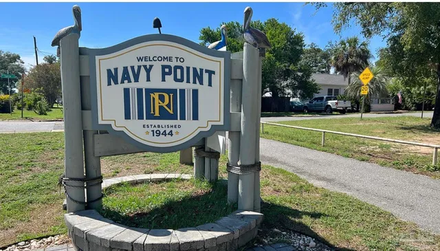 a view of a kitchen with stainless steel appliances granite countertop a sink window and cabinets