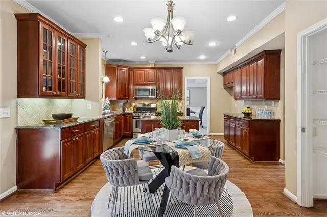a kitchen with granite countertop cabinets a dining table and chairs