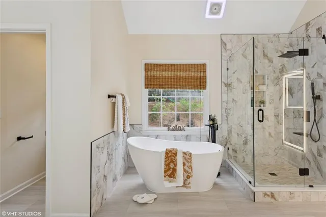 a bathroom with a tub sink and mirror