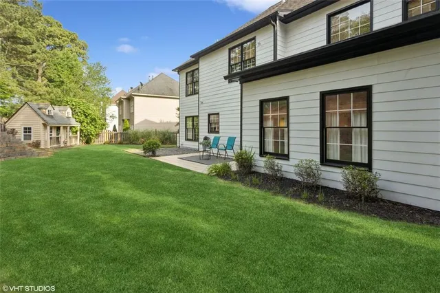 a view of a white house with a large windows and a table and chairs