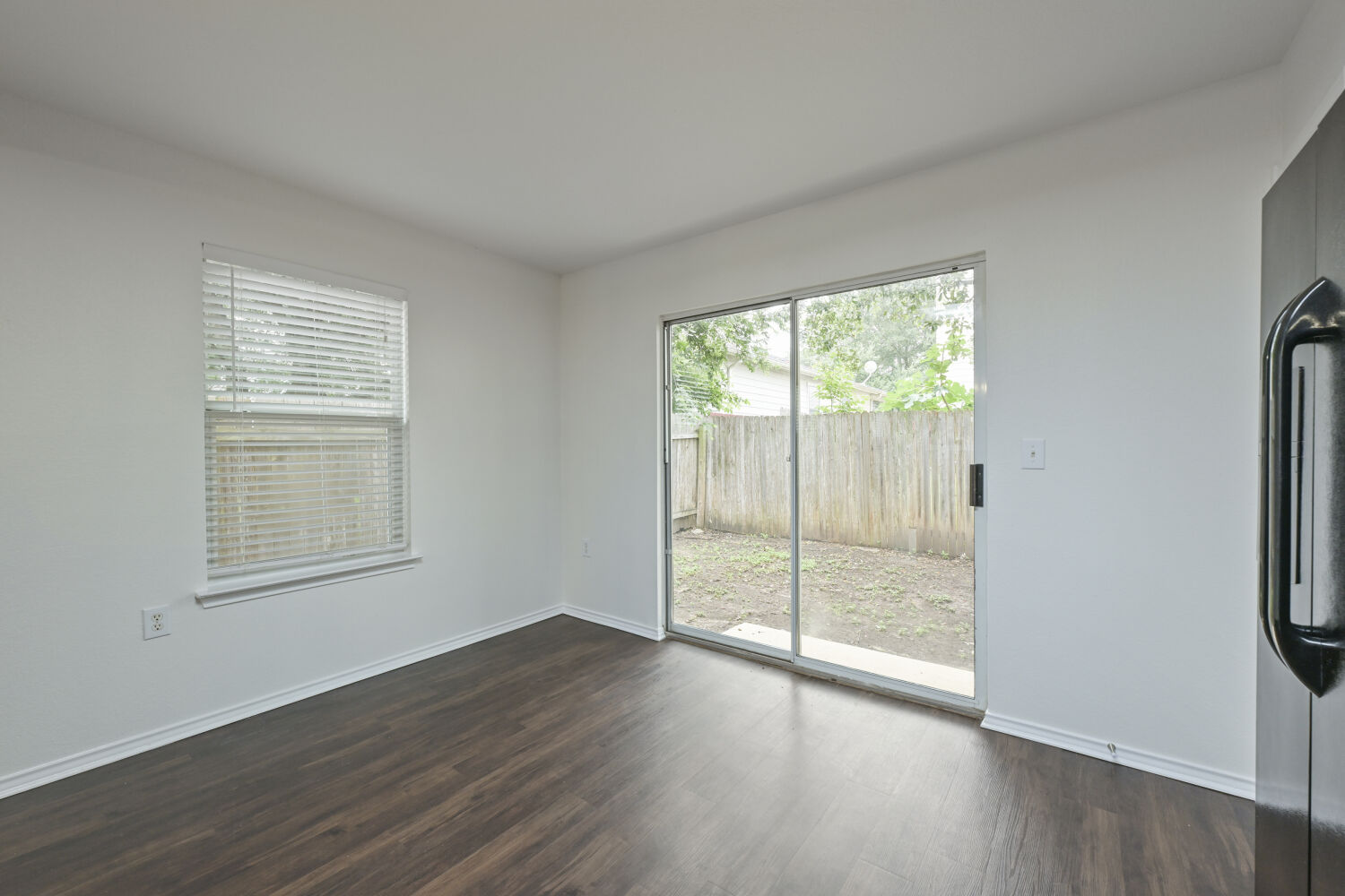 6733 Doyal Drive Austin, TX 78747 - Photo 7 of 28 Hardwood-style flooring extends through this room, with a large sliding door leading to a private outdoor area.