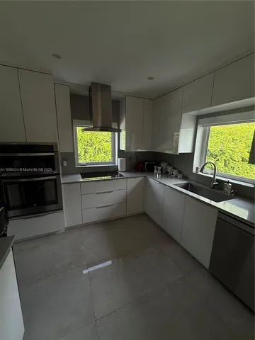 a kitchen with granite countertop a stove a sink and a microwave