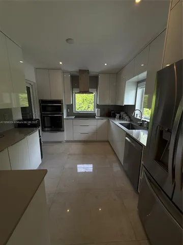 a kitchen with stainless steel appliances granite countertop a refrigerator a stove a sink and a microwave