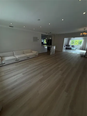 an empty room with wooden floor and outdoor space