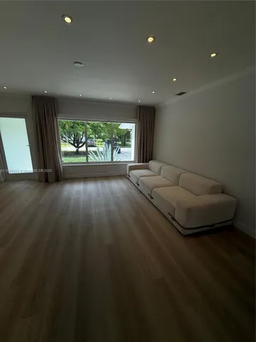 a view of a livingroom with furniture and floor to ceiling window