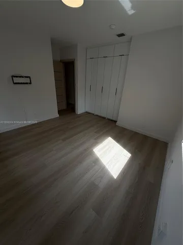 a view of empty room with wooden floor and cabinet