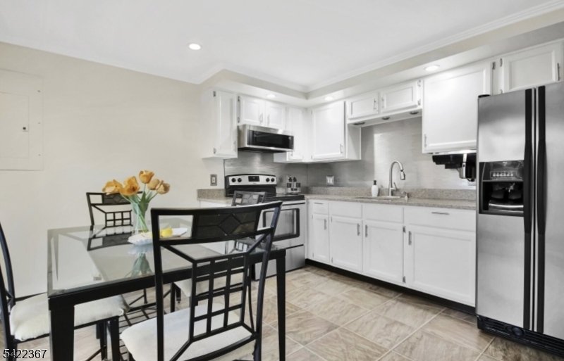 3 Prospect Street, Unit 2D Mount Arlington, NJ 07856 - Photo 4 of 20 a kitchen with stainless steel appliances granite countertop a stove a sink a microwave a refrigerator with white cabinets and wooden floor
