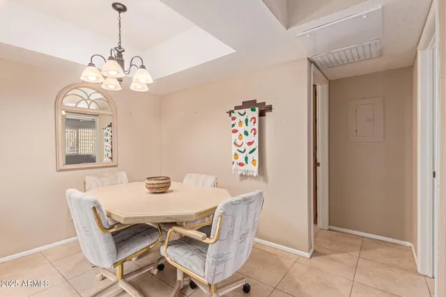 a view of a dining room with furniture a chandelier and kitchen view