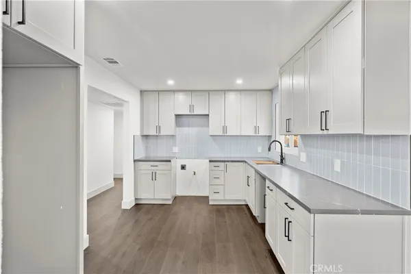 a kitchen with granite countertop white cabinets and white appliances