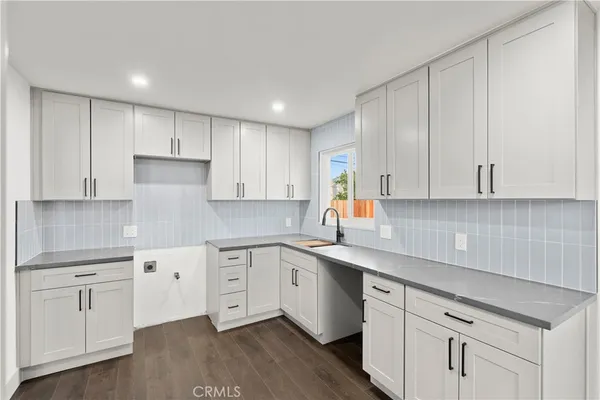 a kitchen with white cabinets white appliances sink and dishwasher