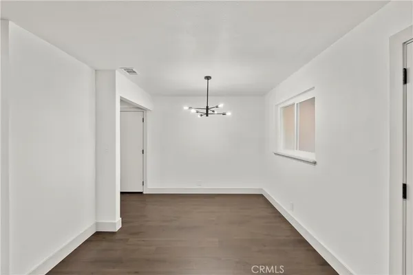 an empty room with chandelier fan