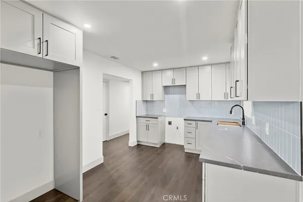 a kitchen with granite countertop white cabinets and white appliances