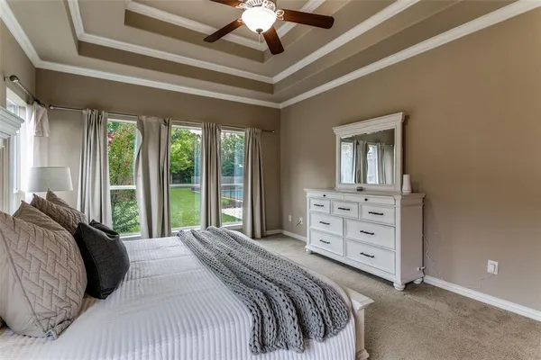a bedroom with a bed a chandelier and a large window