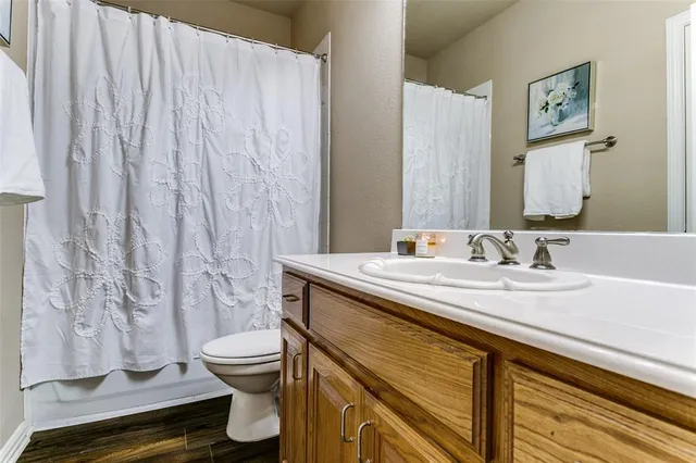 a bathroom with a granite countertop sink a toilet and a mirror