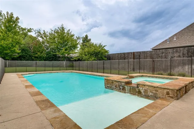 a view of a backyard with swimming pool and furniture