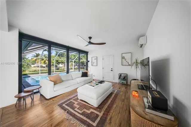 a living room with furniture a flat screen tv and a large window