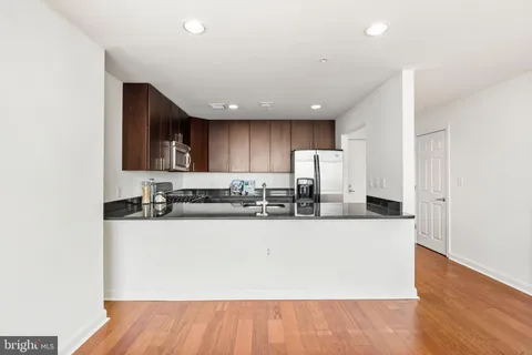 a living room with furniture a large window and a dining table