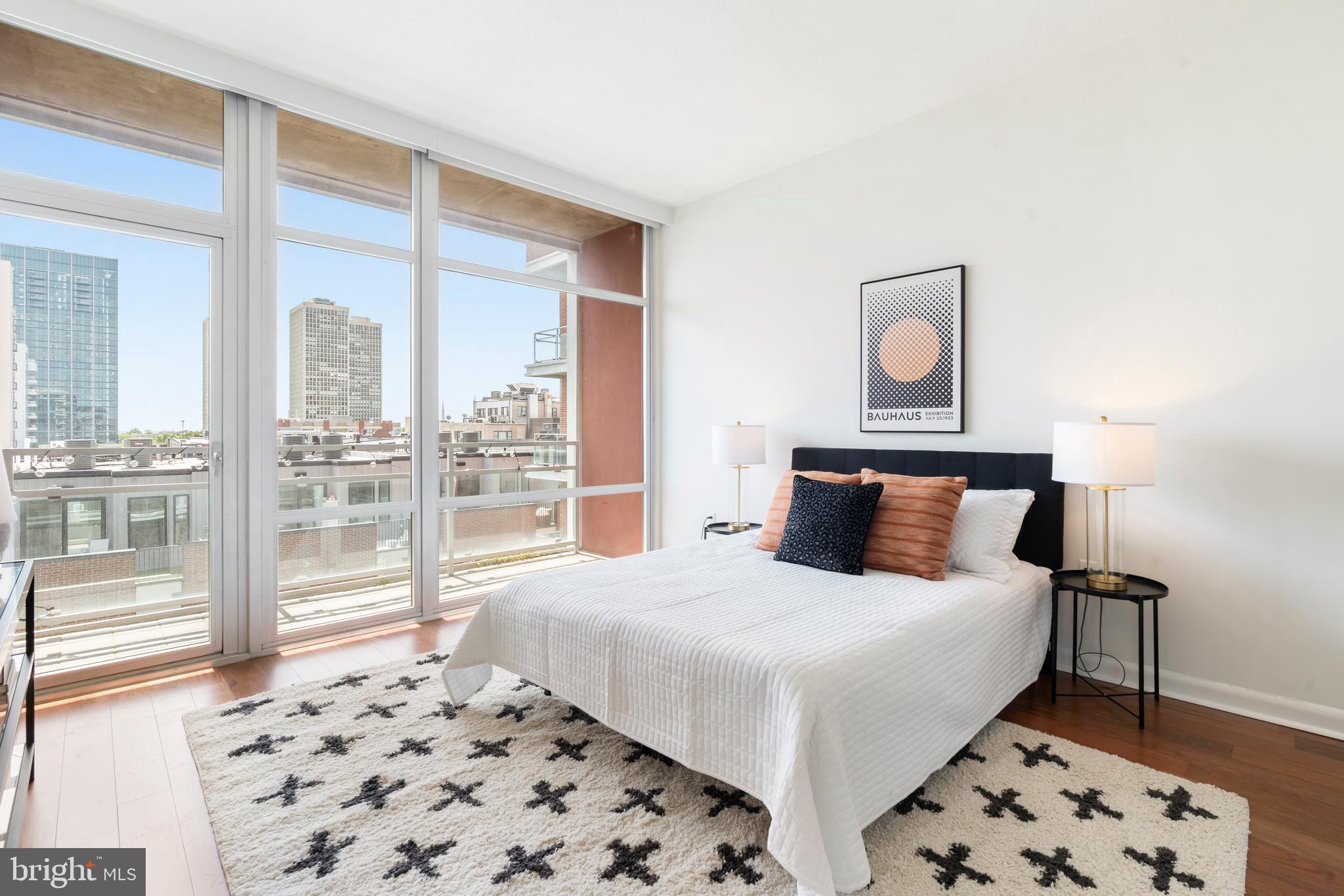 22 South Front Street, Unit 603 Philadelphia, PA 19106 - Photo 35 of 44 a bedroom with a large bed and a lamp next to a window
