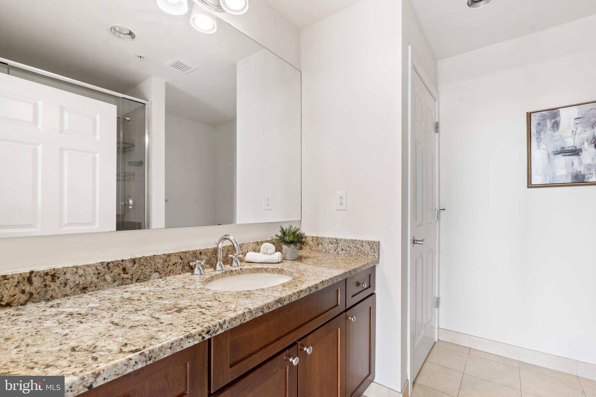 22 South Front Street, Unit 603 Philadelphia, PA 19106 - Photo 39 of 44 a bathroom with a granite countertop sink and a mirror