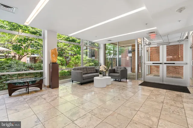 a living room with patio furniture and a large window