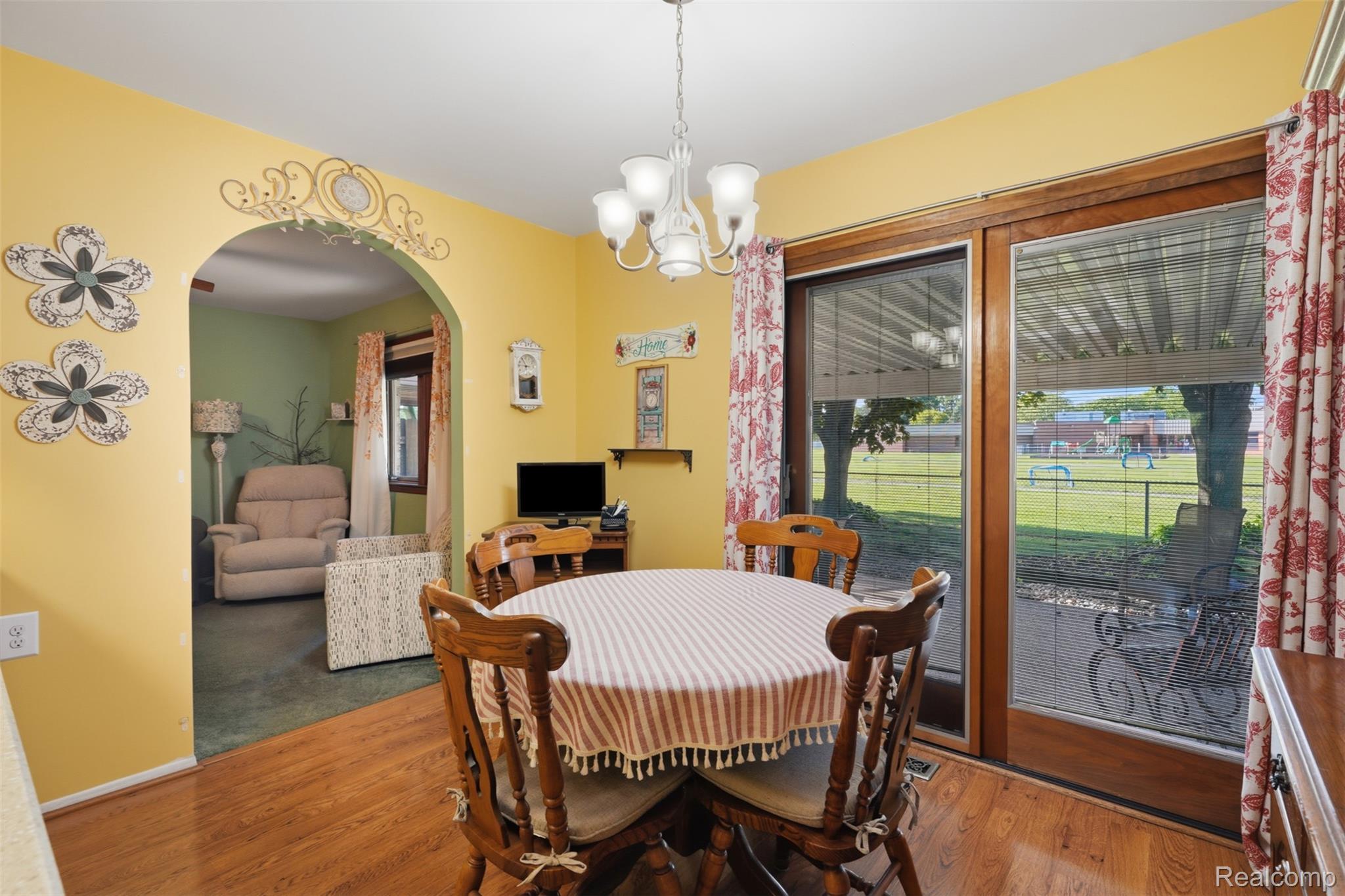 18160 Raleigh Square Drive Southgate, MI 48195 - Photo 12 of 31 Dining area featuring wood-finish flooring, a contemporary chandelier, and an arched entry