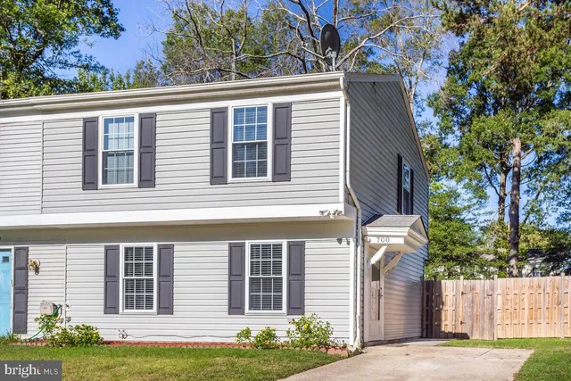 a view of a house with a yard and a large tree