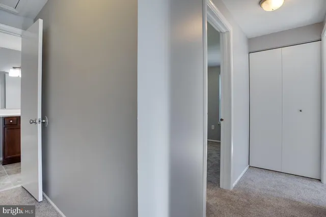 a view of a hallway with closet and bathroom