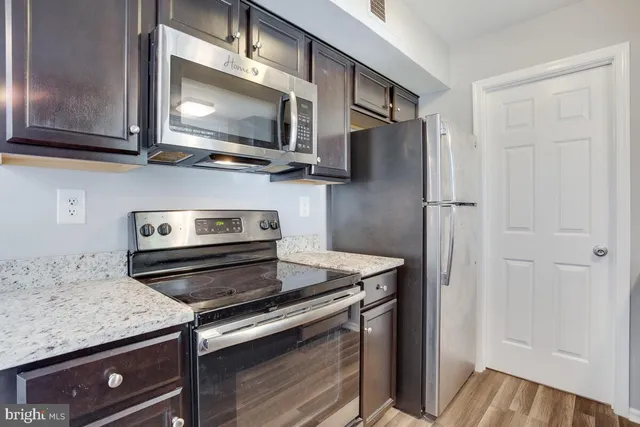 a kitchen with stainless steel appliances granite countertop a stove microwave and refrigerator