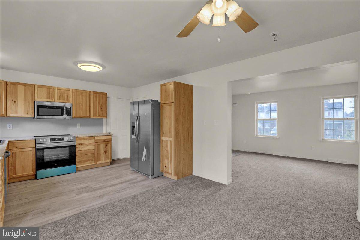 407 Groffdale Road Quarryville, PA 17566 - Photo 12 of 29 a large kitchen with stainless steel appliances granite countertop a refrigerator a stove a sink dishwasher a oven with white cabinets and wooden floor