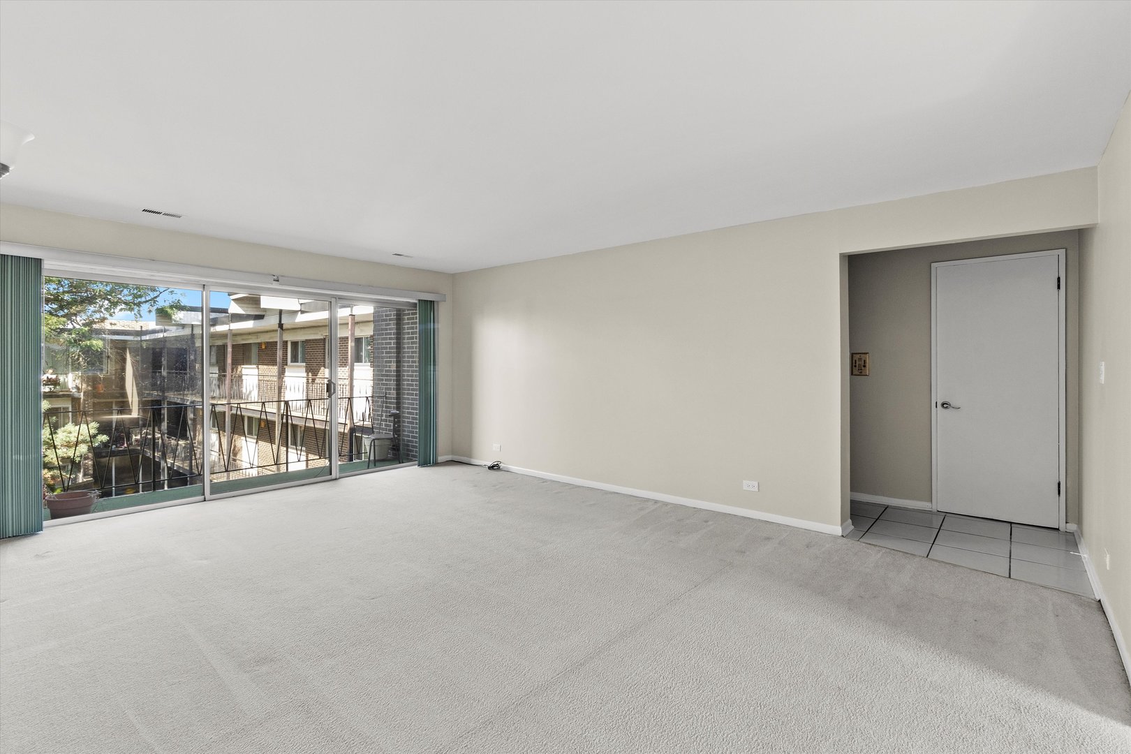 10124 Peach Parkway, Unit 208 Skokie, IL 60076 - Photo 5 of 38 a view of an empty room with a sliding door