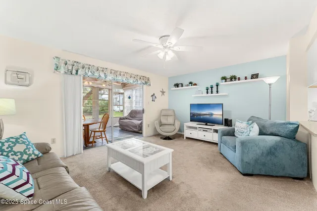 a living room with furniture and a ceiling fan