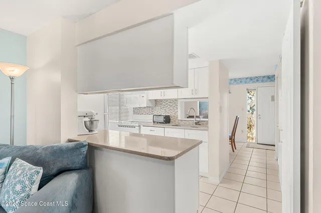a kitchen with stainless steel appliances granite countertop a sink and a refrigerator