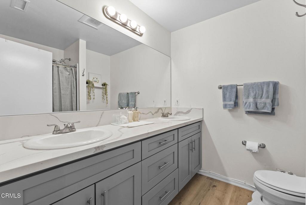 2730 Jill Place Port Hueneme, CA 93041 - Photo 13 of 25 a bathroom with a granite countertop sink a toilet and a mirror