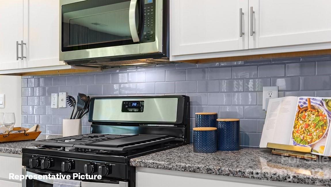 3791 Charles Street Northwest Conover, NC 28613 - Photo 7 of 32 a kitchen with stainless steel appliances granite countertop a stove and a microwave