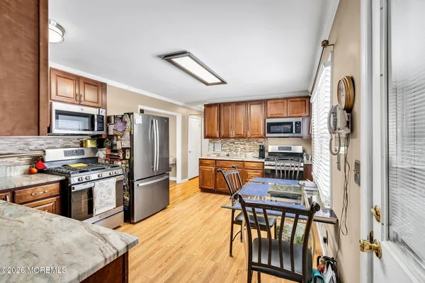 a kitchen with stainless steel appliances granite countertop a stove sink microwave and refrigerator