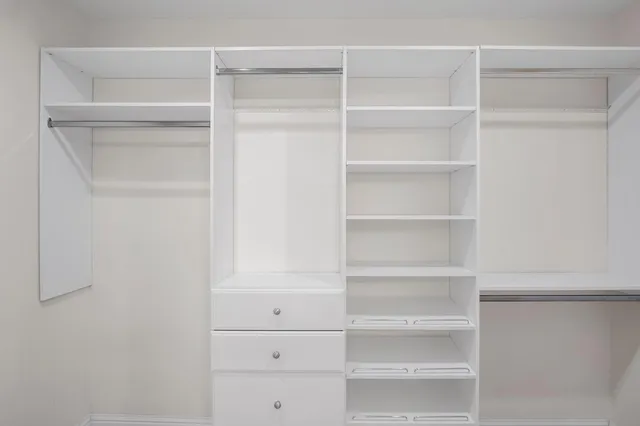 a view of walk in closet with empty racks